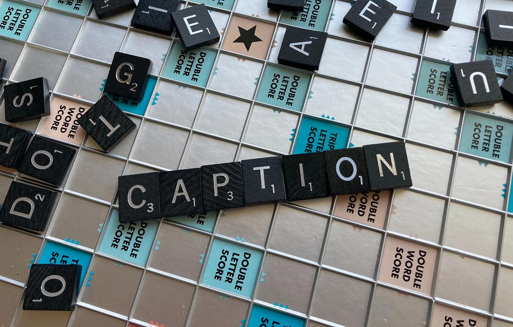 a scrabble board with the word caption spelled out