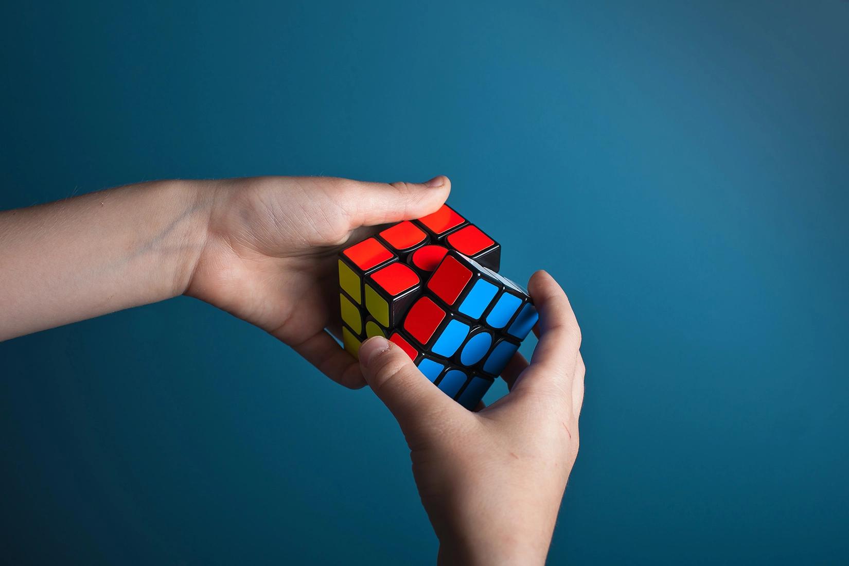 a person solving a rubiks cube puzzle